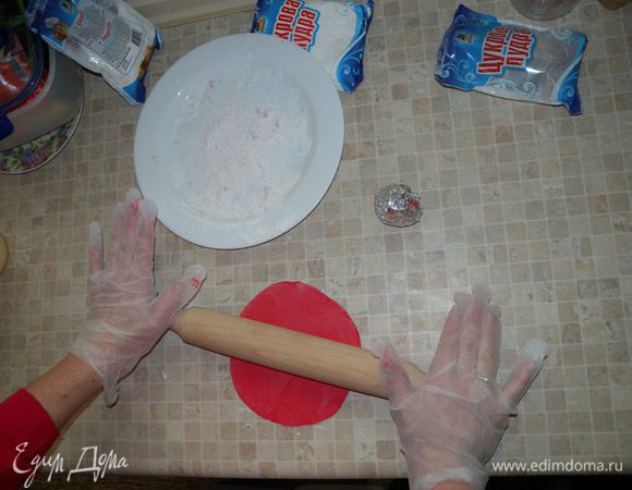 2. Цветную мастику лучше делать в перчатках. Взять часть мастики для одного цветка, остальную - в фольгу. Если она застынет, можно опять на пару сек в микроволновку. Работайте с теплой мастикой. 