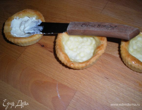 В тарталетки положить по чайной ложке творожного сыра.