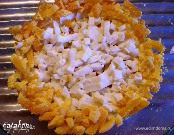 Яйца почистить, отделить белки от желтков и мелко порезать. В салатник на дно выложить огурцы, затем крабовые палочки и яичный белок. Яичный желток выложить кольцом вдоль стенки салатника.