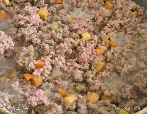 Затем выложить в сковороду фарш, слегка прожарить, влить вино и разведенную в небольшом количестве воды томатную пасту. Посолить и поперчить. Тушить на медленном огне около часа. Через 30 минут от начала тушения добавить сливки.