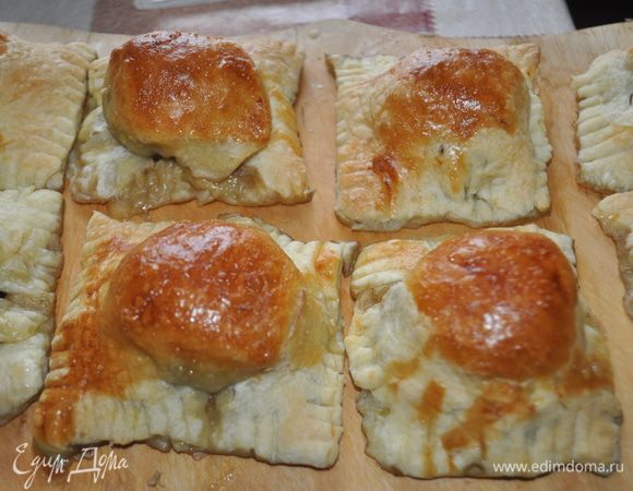 На противень,застланный бумагой для выпечки разложить равиоли,смазать взбитым яйцом и поместить в холодную духовку,сразу включить духовку на 200С. На дно духовки поставить противень с горячей водой. Готовить 30-35 мин.