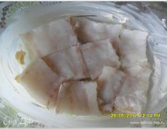 Вымыть рыбное филе, мороженное филе разморозить, нарезать крупными кусочками. Огнеупорную форму смазать маслом, выложить рыбу.
