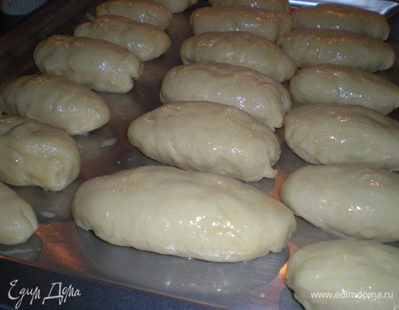 Можно сделать одним пирогом,а я решила сделать пирожки с зеленым луком и яйцом.Делим тесто на кусочки шарики,из каждого шарика делаем лепешку и выкладываем начинку.Скрепляем.Укладываем на противень,даем тесту-пирожку отдохнуть и подружиться с начинкой.Смазываем разболтанным яйцом и отправляем в разогретую духовку. 