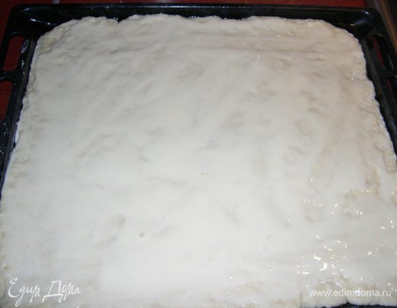 Смажьте тесто сметанной намазкой.
