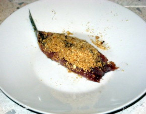 Кильку положить шкуркой вниз и распределить сверху начинку. Завернуть кильку, начиная с головной части, чтобы хвостик торчал наружу. Надеть на деревянную шпажку. Надеть на шпажку ломтик лимона. 