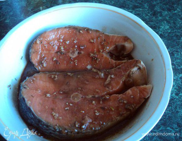 Залить маринадом стейки семги, накрыть посуду пищевой пленкой и поставить в холодильник на 1 час мариноваться.