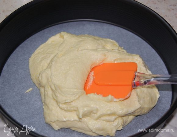 Дно формы выстлать пергаментной бумагой, бока смазать сливочным маслом. Тесто выложить в форму, разровнять.