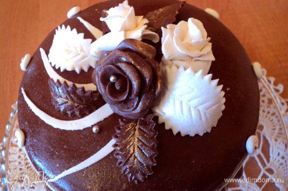 Основную часть шоколадной мастики раскатать и накрыть торт, разгладить и декорировать бока. Верх и бока украсить цветами из мастики, пищевыми бусинками.