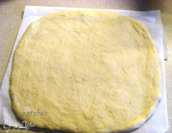 Мягкое тесто подмесить и на пекарской бумаге раскатать пласт толщиной 1 см.