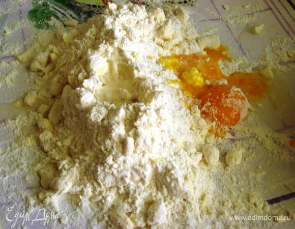 Делаем углубление, добавляем  воду и желтки. Замешиваем тесто (добавляем остальную муку). Это тесто важно сделать быстро, чтобы масло не успело растаять! Тут лучше не домесить, тогда маленькие кусочки масла в тесте сделают его при выпечке слоеным и рассыпчастым. Если перестараться тесто будет жестким.