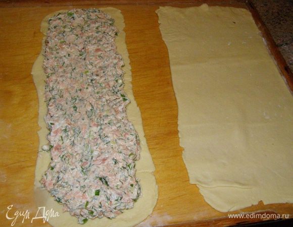 Смажем полоски меньшей ширины водой и выложим на них начинку. Если вы будете делать сразу два штруделя, то выкладывайте начинку двумя полосками с зазором между ними