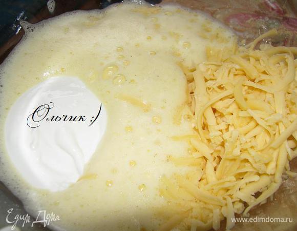Взбиваем 1 яйцо со щепоткой соли. Добавляем оставшийся тертый сыр и 100 г сметаны, аккуратно перемешиваем.