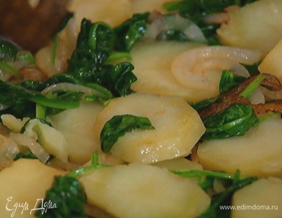 Добавить в сковороду к луку сначала листья шпината, а затем картофель. Увеличить огонь, чтобы картофель лучше поджарился.