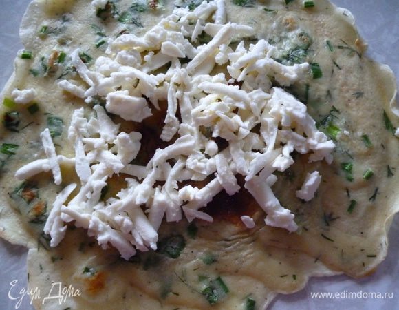 Приготовим блинчики:яйца взбить с щепоткой соли,добавить подсолнечное масло и муку,взбить и добавить молоко и зелень,взбить.Из этой смеси испечь блинчики.Каждый блинчик посыпать натертым на крупной терке козьим сыром.
