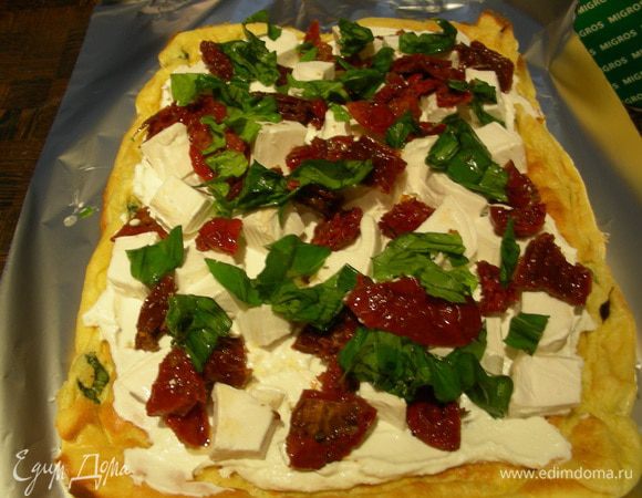 Произвольно распределяем по нему сыр, томаты и базилик. Я это сделала очень щедро, можно было поменьше начинки положить, так как потом было тяжеловато его в рулет скрутить, но все отлично получилось.
