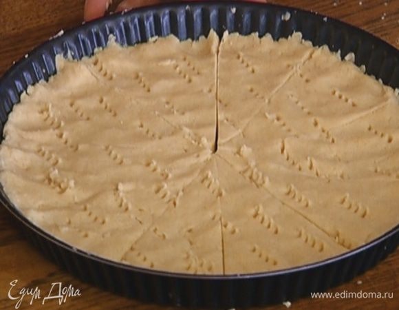 Выложить тесто в широкую с низкими бортами форму для выпечки, разровнять и часто наколоть вилкой. Затем острым ножом разрезать на 8 равных частей.