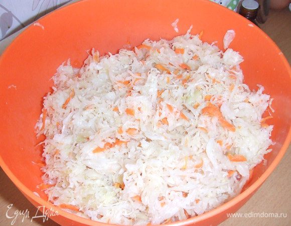 Квашеную капусту порубить сечкой в деревянной миске, обжарить в растительном масле, соединить с отдельно обжаренным нашинкованным репчатым луком и шампиньонными,  приправить сахаром, солью, перцем, перемешать.
Тесто раскатать, перенести на противень, разровнять. На тесто выложить начинку,сделать из теста сеточку. Пирог поставить на 30 мин. в теплое место, чтоб он поднялся и смазать яйцом. Выпекать при температуре 180 С. 35-40 мин.