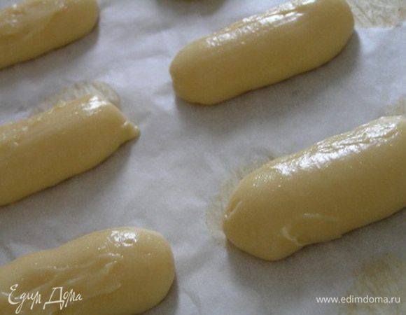 Заполнить заварным тестом кондитерский шприц и отсадить на выстеленный бумагой для выпечки противень 12 полосок, длинной 6-9 см на расстоянии 3-4 см друг от друга. В процессе выпечки изделия хорошо увеличиваются :)