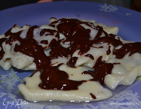 Раскатать тесто,вырезать из него кружочки (d=7см), смазать белком, выложить начинку в центр круга и закрепить тщательно края в форме полумесяца. 
Вареники отваривать в большом количестве подсоленной воды на медленном огне до готовности (около 10 минут).
Для поливки: 
растопить шоколад со сливочным маслом и перемешать. Растапливать можно на водяной бане или в микроволновке. 
Обильно полить горячие вареники шоколадом.
Черника с шоколадом это ОЧЕНЬ вкусно:))) Можно получать удовольствие!