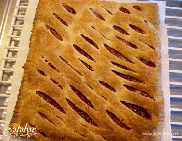 По истечении времени, когда слойка подрумянится, достать из духовки противень. Стащить за бумагу слойку на бумажное полотенце, аккуратно положить на решётку, накрыть салфеткой и оставить на 20-25 минут для остывания.