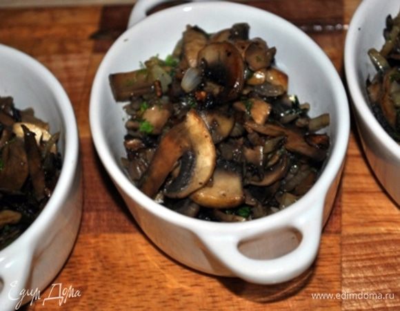 Лук почистить и мелко порубить. Грибы почистить/помыть и порезать пластинками. В сковороде нагреть масло, обжарить лук, добавить грибы и жарить, пока из грибов не испарится вода, затем посолить, поперчить, добавить зелень. Выложить грибы в порционные формочки, 