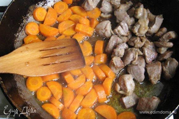 На растительном масле обжариваем кусочки мяса. Когда оно почти готово на вторую половину сковороды выкладываем крупно нарезанную морковь и жарим минут пять.