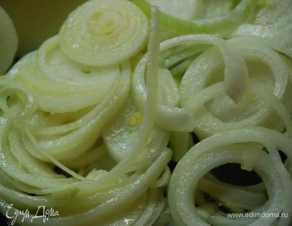 Лук нарежем тонкими кольцами и немного обжарим в сливочном масле. 