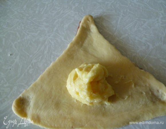 Слегка оттягиваем уголки,на широкую часть выкладываем ложку начинки.