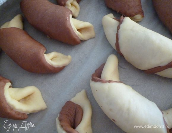 Выкладываем на противень и даем расстояться(подняться)15-20минут.Затем смазать их взбитым яйцом,перед тем как отправить в духовку.Я на один противень распределила светлые и темные рогалики.По светлым легче определить когда они уже испеклись.Поэтому,даже если вы решите все рогалики испечь с шоколадным верхом,один на противень сделайте светлый,тогда точно не передержите в духовке.