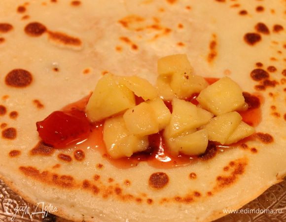 Выпекаем блинчики, один за другим. А потом на каждый кладем начинку -  яблоки и немного клубничного джема. 