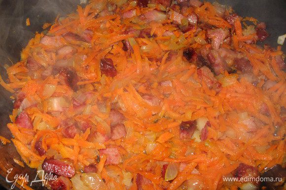 К грудинке добавляем лук и натертую морковь, продолжаем жарить,пусть потомится на маленьком огне, отдаст овощам свои вкус и запах, заодно подтопится жирок.