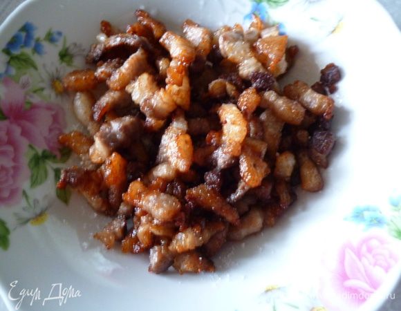 Нагреем сковородку с двумя ложками растительного масла и обжарим полоски бекона до золотистого цвета,что бы он стал хрустящим.Убираем бекон в сторону и слегка его присолим,а на образовавшемся небольшом количества жира спасеруем лук до прозрачности и оставим его остывать в сковородке.