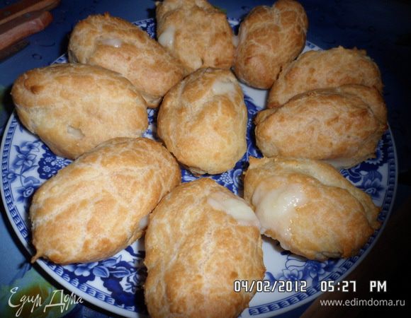 Готовым эклерам дать остыть. Наполнить кондитерский мешок кремом. В эклерах проделать небольшие дырочки и через них наполнить кремом. 
Украсить тертым шоколадом.