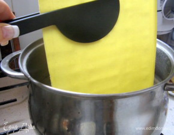 Вскипятить воду в большой кастрюле.Пласты пасты опустить в кипяток на пару минут, а потом  откинуть на полотенце, чтоб дать стечь воде. 