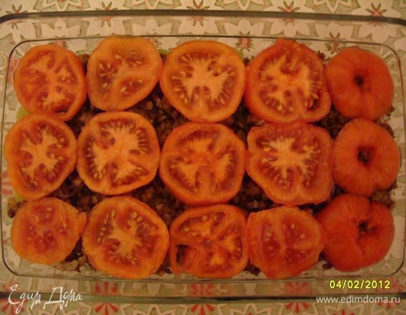 Снять с помидоров кожицу, нарезать кольцами и выложить на мясной фарш (3-й слой).