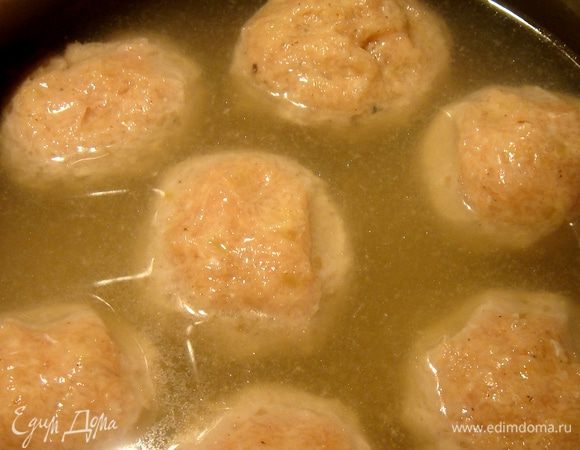 Бульон поставить подогреваться на средний огонь. Сформовать тефтели размером с теннисный мяч, опустить их в горячий бульон и проварить в течении 15 минут. Переложить тефтели в отдельную посуду, а в бульон влить сливки и прогреть смесь.