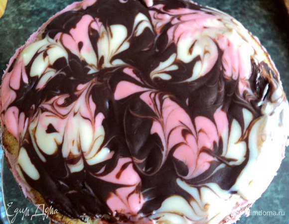 Торт вынуть из формы. Для украшения выложить черный шоколад и белый шоколад, разделив на 2 части,  в разные емкости. Добавить в каждую емкость с шоколадом  по 1 ст.ложке сливок и растопить шоколад в микроволновке или на водяной массе. В одну часть растопленного белого шоколада добавить крупинку пищевого красителя, хорошо перемешать до однородного розового цвета. Затем ложкой выложить на верх торта поочередно растопленный шоколад в произвольном порядке. Зубочисткой нарисовать узоры. Поставить торт в холодильник на 5 мин для застывания шоколадаю