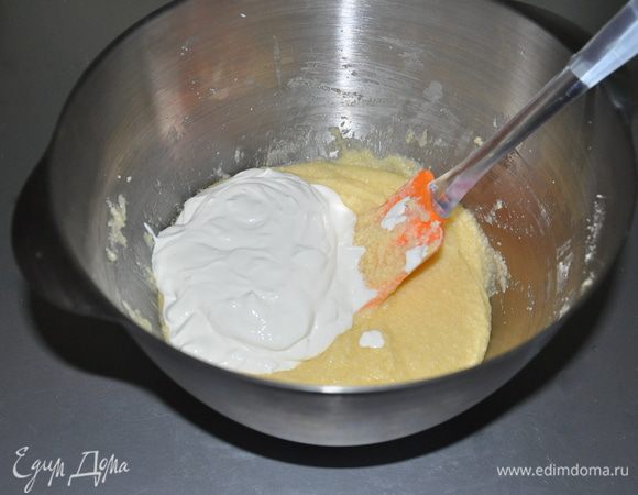 Добавляем к яично-масленной смеси сметану. И вымешиваем до однородности.