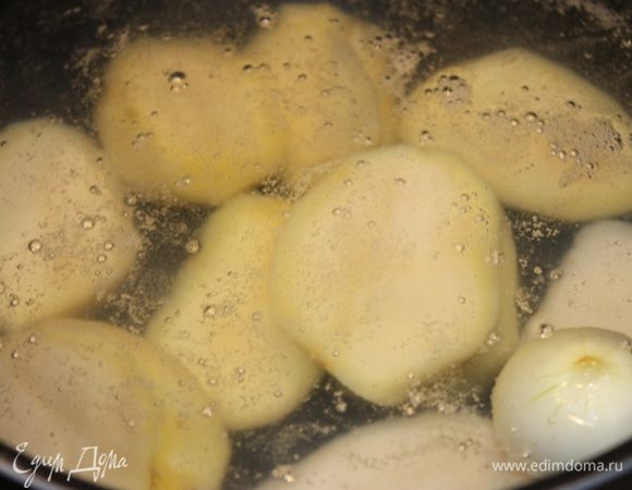 Картофель почистить, опустить в слегка подсоленную кипящую воду, туда же положить 1 небольшую луковку целиком. 