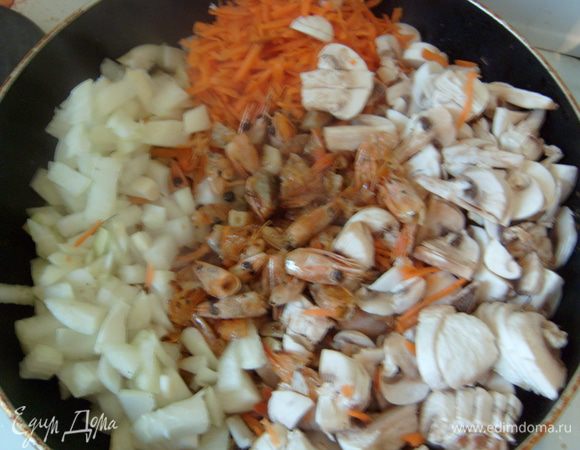 Тем временем натереть на крупной терке морковь, нарезать лук, шампиньоны. Добавить к головам и пассеровать 5-7 минут.