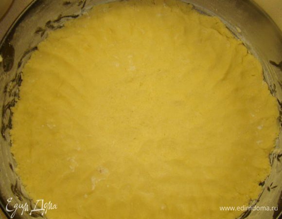 Творог осторожно перемешать со взбитыми яйцами  
Дно формы смазать маргарином, посыпать мукой, выстелить одну  часть песочного теста, поставить в духовку на 5 минут при 170 градусах.