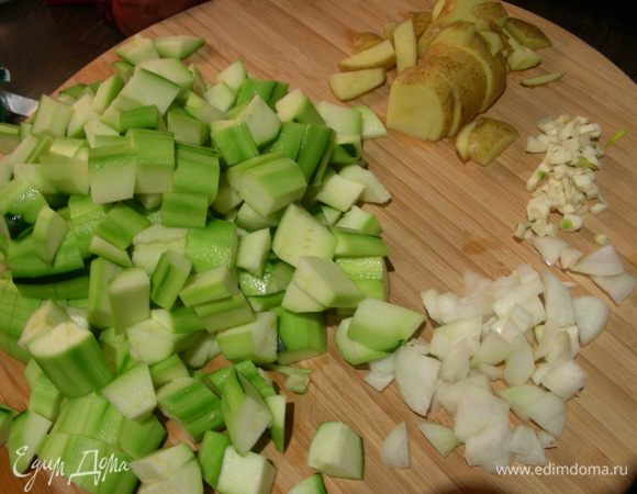 Картофель, лук и цукини (кроме 1 половинки) режем кубиком, чеснок измельчаем.
