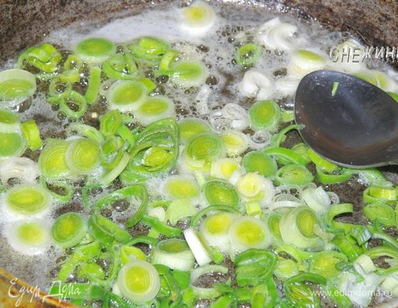 Лук-порей порезать колечками. В сковороде разогреть оливковое (растительное) масло и отправить в него лук. Держать на маленьком огне.