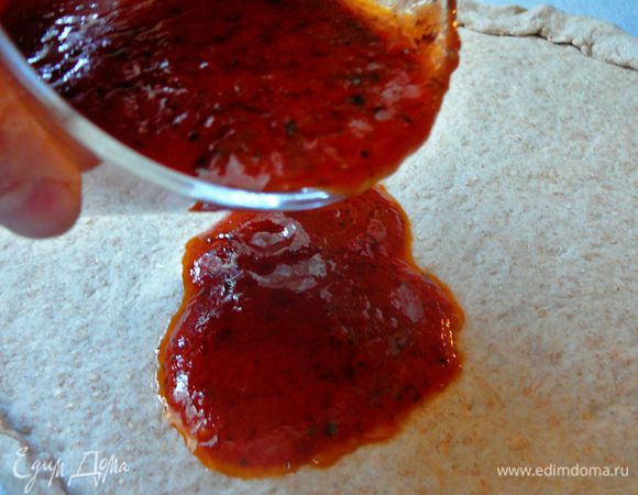 Наливаем соус,примерно 1/3 на тесто,равномерно распределяем его при помощи кисточки или другого сподручного средства:)