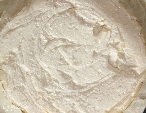 Раскатать одну часть теста в круг немного большего размера, чем диаметр вашей формы. Выложить тесто в смазанную сливочным маслом форму. Выложить на тесто творожную начинку.