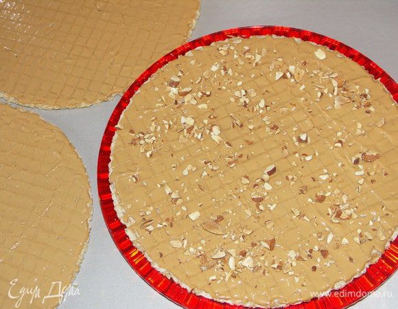 Нижний смазываем, посыпаем орехами и накрываем вторым смазанной стороной вниз.