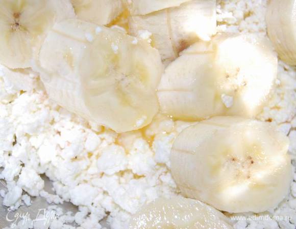 Приготовим творожные шарики. Для этого в творог добавим половину яйца,банан (разомнем его вилкой).