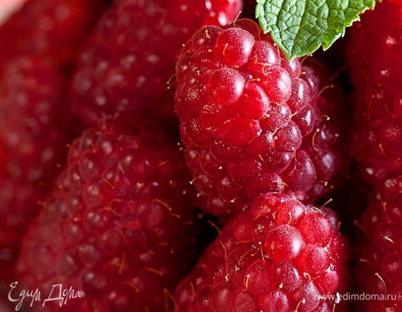 На дно вафельных стаканчиков укладываем ягоды малины.