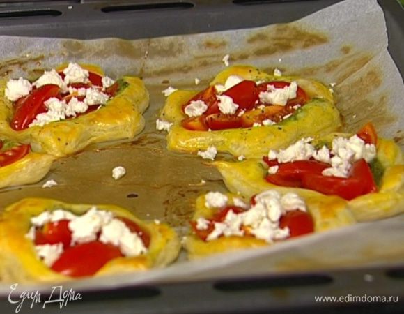 Как только тарталетки начнут румяниться, вынуть противень из духовки, положить на каждую тарталетку по нескольку кусочков феты и вернуть в духовку еще на пару минут.