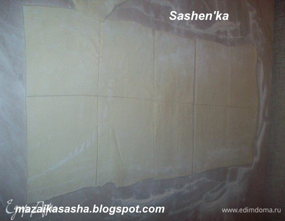 припытить стол мукой. Холодное слоеное тесто раскатать. Помните, что тесто раскатывается в одном на правлении. Разрезать на квадратики. На один квадратик выложить начинку, смазать края взбитым яйцом и хорошенько закрепить. Ножом сделать по краям слойки вмятинки, это позволит тесту  более крепко склеится и не даст начинке при выпекании выбраться наружу.